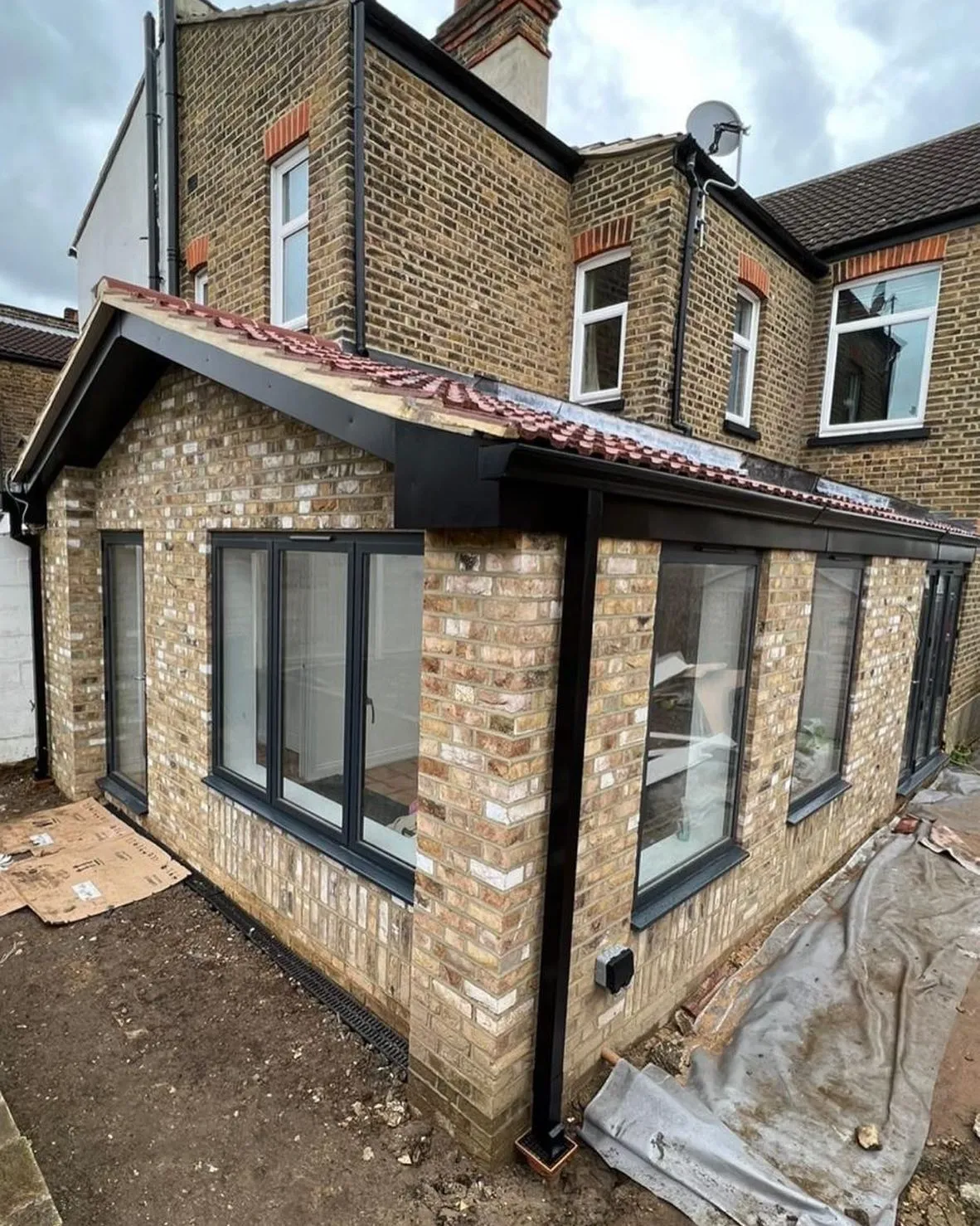 a brick building with a metal roof and a black awning